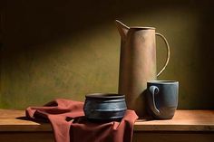 a painting of a coffee pot and cup on a wooden table next to a red cloth