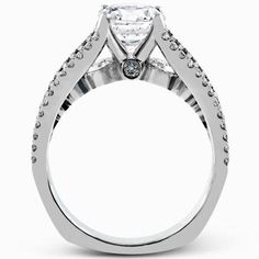 a white gold ring with an oval cut diamond in the center and pave set shoulders