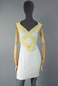 Features - 100% Authentic THIERRY MUGLER. - Short white dress with yellow stripe crisscross panel at the back. - Bow/ ribbon accent at the centre front. - Snap buttons and zipper closure at the back. - Label reads: THIERRY MUGLER PARIS, Made in France. - Size 42. - Fabric content: 100% Silk, 100% Cotton. - Fully lined. - Very good vintage condition. Measurements taken laid flat, please double bust, waist and hips: Shoulder: 15.74 inches (40 cm) Bust: 16.92 inches (43 cm) Waist: 14.56 inches (37 White Dresses With Crisscross Straps And Cross Back, White Cross Back Dresses With Crisscross Straps, White Cross Back Dress With Tie Detail, White Fitted Dress With Crisscross Straps, White Sleeveless Dress With Ribbon Detail, Fitted Summer Dress With Ribbon Detail, White Spring Dress With Ribbon Detail, White Spring Dresses With Ribbon Detail, White Dress With Ribbon Detail For Spring