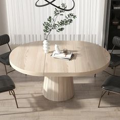 a round wooden table with four chairs around it and a vase on the table top