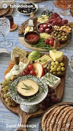 an assortment of cheeses, crackers and other foods on a wooden platter