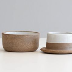 two white and brown bowls sitting next to each other