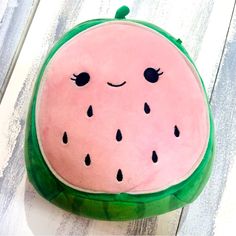 a watermelon pillow sitting on top of a wooden table