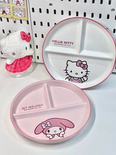 two hello kitty plates sitting next to each other