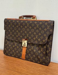 DESCRIPTION 20th c., leather handle, flap closure, (2) interior sections, (1) interior zippered pocket, 12"h x 16"l x 2"d CONDITION Good/fair, some wear, scuffs, stains to handle, missing key Travel Luggage, Leather Handle, Louis Vuitton Monogram, Louis Vuitton, Monogram, Key, Purses And Bags, Zipper, Leather