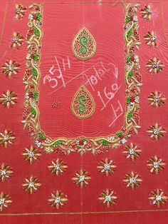 an embroidered red cloth with gold and green designs on it, in front of a white background