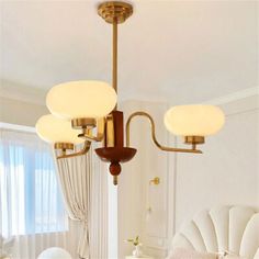 a chandelier hanging from the ceiling in a room with white walls and furniture