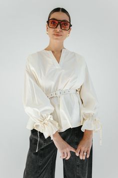 STYLE + FIT NOTES: Modern chic meets timeless elegance with the Cosette Pleated Blouse! This blouse is more than just a wardrobe staple, it is a wardrobe statement, plus the belt is included! Style with your fav denim for an effortlessly stylish look. This blouse has a relaxed fit so size down for a more fitted look. Elegant Belted Top For Summer, Elegant Belted Summer Top, Elegant Summer Belted Top, Belted Blouse For Workwear, Elegant Long Sleeve Belted Top, Elegant Belted Blouse For Work, Chic Long Sleeve Belted Blouse, Elegant Belted Blouse For Spring, Elegant Spring Belted Blouse