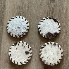 four animal hide coasters on a table for $ 26 each