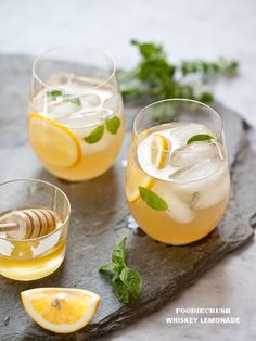 two glasses filled with lemonade and mint on a tray