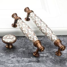 two door handles and knobs on the side of a white door with floral designs