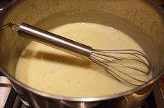 a metal bowl filled with liquid and whisk