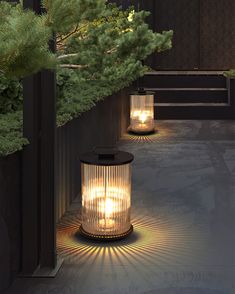 two lit lanterns sitting on the side of a building