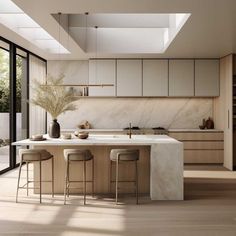 a kitchen with marble counter tops and stools in front of an open floor plan