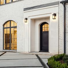 a white brick building with black doors and windows