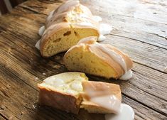 a loaf of bread with icing sitting on top of a wooden table