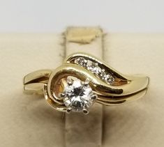 "We do not check prongs for wear or stones for looseness. All items are sold as is-noting that we are a resale shop so everything here had a previous owner! We will include flaws in the description when noted. This is one of the reasons our items are more affordable than new at a jewelry store. Vintage 14K Yellow Gold Fused Ring Set with a .30 Carat Round Diamond, Size 6.5. There is 4 smaller diamonds below main stone. Stamped 14K inside band. Weighs 2.2 dwt. Are these stones real or fake? Aside Collectible 14k Gold Diamond Ring, Collectible Yellow Gold Diamond Ring With Round Cut, Collectible Brilliant Cut Yellow Gold Diamond Ring, Collectible Yellow Gold Brilliant Cut Diamond Ring, Collectible 14k Gold Diamond Ring With Round Cut, Yellow Gold Bypass Ring For Anniversary, Classic Bypass Ring With Vs Clarity For Anniversary, 14k Gold Diamond Ring With Prong Setting For Collectors, 14k Gold Bypass Ring For Anniversary