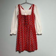 Vintage Size Small Red Floral Oktoberfest Trachten Dirndl Dress Germany Pinafore * Vintage Red Floral Dirndl with White Piping Trim * Zip Front Accented with 2 Rows of Embossed Buttons * Floral Pattern Has Blue Flowers * White Eyelet Peplum Square Neck Blouse with Long Sleeves and Ruffle Cuffs * Lined Bodice * Very Good Pre-Loved Vintage Condition: the blouse has some loose threads on the eyelet and some yellow spots Measurements Laid Flat: Length:  35 Inches Chest:  16 Inches Waist:  13 Inches Waist to Hem:  20 Inches Blouse Chest:   18 Inches Blouse Sleeve From Neck:  24 Inches Pinafore Vintage, Square Neck Blouse, Blouse With Long Sleeves, Dirndl Dress, Flowers White, White Eyelet, American Women, Womens Midi Dresses, Dress Clothes For Women