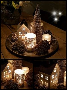 pine cones and lit candles are arranged on a tray in the shape of houses with windows