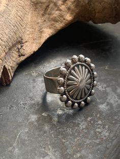 This is such a special stering silver (unstamped) ring that I had made from a vintage concho pin from the American Southwest. I cannot say for sure, but the pin (now the face of the ring)  is likely Navajo/Diné in origin. It is a solid and well made piece with a nice weight to it.  The face of the ring measures 1 inch in diameter. The band measures  5/16 inch wide. It is between size 6.25 and 6.5 but due to the wide band it fits snugly.  Weight: 12.8 g Unique Concho Jewelry Gift, Adjustable Antique Concho Jewelry, Antique Adjustable Concho Jewelry, Southwestern Concho Ring Jewelry, Bohemian Oval Stamped Jewelry, Western Jewelry In Antique Silver With Concho Details, Oval Silver Western Jewelry, Western Antique Silver Jewelry With Concho, Silver Concho Jewelry For Gift