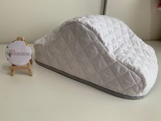 a bed sitting on top of a white table next to a small wooden easel