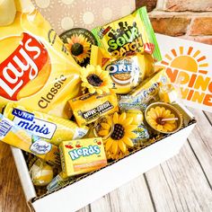 a box filled with snacks and candy sitting on top of a wooden table