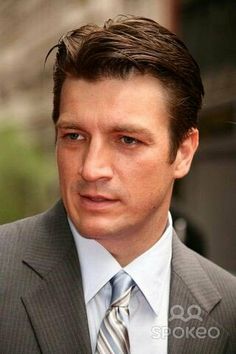 a close up of a person wearing a suit and tie with a serious look on his face