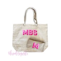 a white bag with pink letters on it and a small purse next to it that says mm