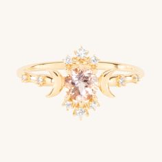 a gold ring with an oval shaped morganite and diamonds on the band, set in 18k yellow gold