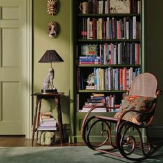 a rocking chair sitting in front of a book shelf filled with books