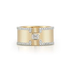 a yellow gold ring with diamonds on the sides and a baguette cut in the middle