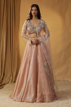 Peach organza blouse with sequins, pearls and beads embroidery. Paired with mirror, shells embroidery dupatta and solid lehenga. - Aza Fashions Elegant Embellished Chanderi Lehenga, Embellished Tissue Silk Lehenga For Festivals, Embellished Silk Lehenga For Navratri, Navratri Embellished Silk Lehenga, Wedding Embellished Tissue Silk Choli, Embellished Silk Lehenga For Reception, Party Wear Choli With Pearl Embroidery For Festive Season, Pearl Embroidered Chanderi Sets For Reception, Chanderi Sets With Pearl Embroidery For Reception