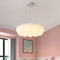 a bed room with pink walls and a white light hanging from the ceiling above it