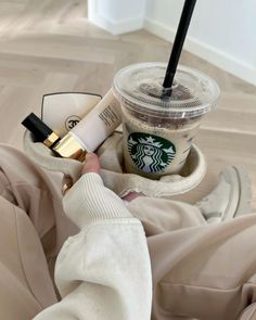 a person holding a starbucks cup with a straw in it