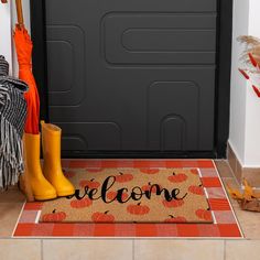 a welcome mat with rubber boots and an umbrella