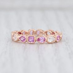 a pink and white diamond ring on top of a table