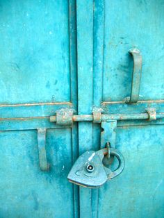 an old blue door with a lock on it