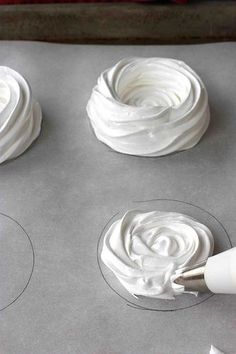 white icing being spread on top of cupcakes in the shape of circles