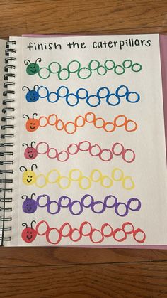 an open spiral notebook with colored crochet designs on it and the words finish the caterpillars