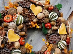 a wreath made out of pine cones, acorns, and other autumn decorations