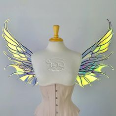 a white corset with yellow wings on top of a mannequin head