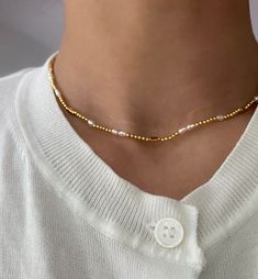 Dainty and delicate, this gold beaded choker necklace is our new favorite. This delicate choker features tiny gold beads and adorned with a mix of fresh water small pearls. It's full of beach vibes. Wear this beaded choker alone or layer a few of our bolder necklaces. 18k gold plated Brass base Fresh water pearls 3 lengths: 15.5"; 16.5"; 17.3" Gold Beaded Chain Pearl Choker, Minimalist Gold Beaded Necklace With Colorful Beads, Trendy Gold Pearl Choker, Dainty Gold Necklace With Colorful Beads, Trendy Pearl Beaded Necklaces With Tiny Beads, Trendy Pearl Beaded Necklace With Tiny Beads, Gold Beaded Pearl Charm Choker Necklace, Gold Beaded Choker Necklaces With Pearl Charm, Gold Beaded Choker Necklace With Pearl Charm