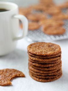 a stack of cookies next to a cup of coffee