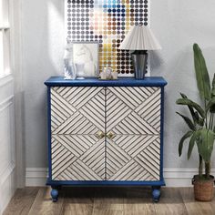 a blue and white cabinet next to a potted plant