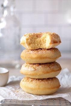 a stack of doughnuts sitting on top of a table next to a cup