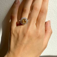 a woman's hand with a yellow and white diamond ring