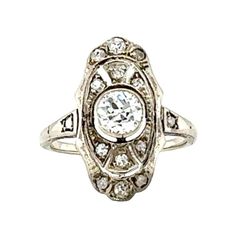 This delicate Edwardian filigree ring, crafted in 14K white gold, captures the refined elegance of the 1910s. At its center, a bezel-set old mine cut diamond weighing 0.45 carats shines with L-M color and SI-1 clarity, offering a subtle warmth and vintage sparkle. Surrounding the center stone are 14 bead-set rose cut diamonds, totaling 0.15 carats, with O-P color and SI-2 clarity, adding a soft glimmer to the intricate filigree design. Measuring 19 mm long by 10 mm wide on the finger and weighin Filigree Design, Filigree Ring, Edwardian Fashion, Rose Cut Diamond, Cocktail Rings, Rose Cut, White Gold Diamonds, Timeless Beauty, Gold Diamond