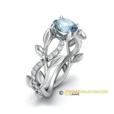 a white gold ring with an aqua blue topazte and diamonds on the side