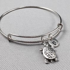 Turtle charm bangle bracelet with hand stamped initial Bracelet is adjustable Add on a birthstone charm for $3.00 https://www.etsy.com/listing/235600956 Additional Hand stamped initial charm $3.50 https://www.etsy.com/listing/232868096 *Go back to Toodaughters https://www.etsy.com/shop/Toodaughters Dinosaur Necklace, Animal Bracelet, Bracelet Initial, Turtle Charm, Personalized Bracelet, Cute Gift Boxes, Bangle Bracelets With Charms, Initial Bracelet, Personalized Bracelets