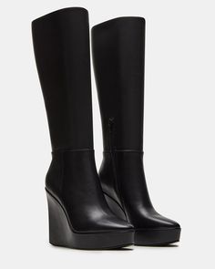 The AKIRA knee-high boot features a platform wedge design and a convenient inside zipper for easy on and off. Elevate your style game with this versatile and stylish boot, perfect for any occasion. 4.5 inch heel height Size 6 measurements: 14 inch shaft circumference, 13.75 inch shaft height Size 8 measurements: 15 inch shaft circumference, 14.75 inch shaft height Size 10 measurements: 16 inch shaft circumference, 15.75 inch shaft height Leather upper material Textile lining Synthetic sock Synth Platform Slip Ons, Knee High Wedge Boots, Black Wedge Boots, Knee High Platform Boots, Platform Boots Women, Summer Wardrobe Staples, Black Wedge, Stylish Boots, 5 Inch Heels